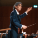 Maestro d'orchestra dirige un'orchestra durante un concerto dal vivo.