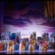 Dettagli scena con ballerini e musicisti in costume tradizionale.