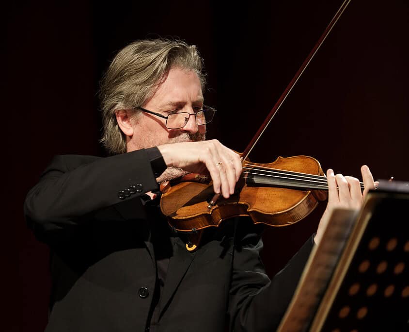 Violinista professionista che suona il violino durante un concerto dal vivo.
