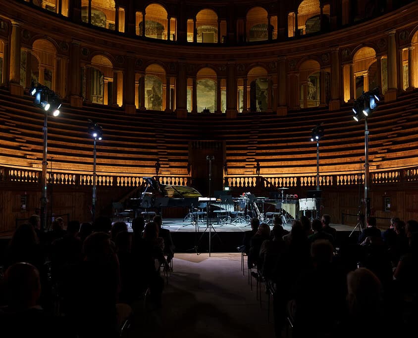 20260519 - 0004 Un palco con pianoforte e strumenti musicali in un teatro storico illuminato, pronto per un concerto.