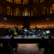 Un concerto di musica classica al Salone Musicale con artisti sul palco e pubblico in sala.