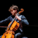 Il giovane musicista suona il violoncello in un concerto di Le Salon Musical.