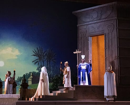 Scena teatrale ispirata all'antica Roma con attori in costumi storici e scenografia monumentale. Atm.