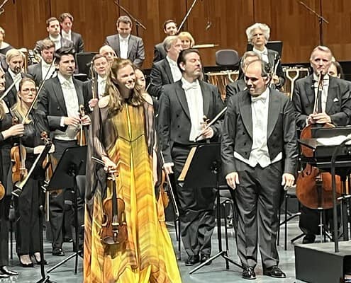 Corale Le Salon Musical in concerto Orchestra sinfonica durante un concerto, musicisti in abiti formali sul palco.