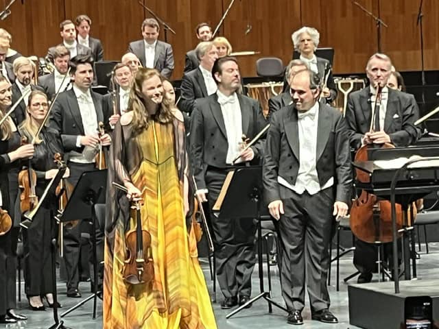 Corale Le Salon Musical in concerto Orchestra sinfonica durante un concerto, musicisti in abiti formali sul palco.