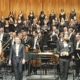 Corale Le Salon Musical durante un'esibizione con orchestre e coro.