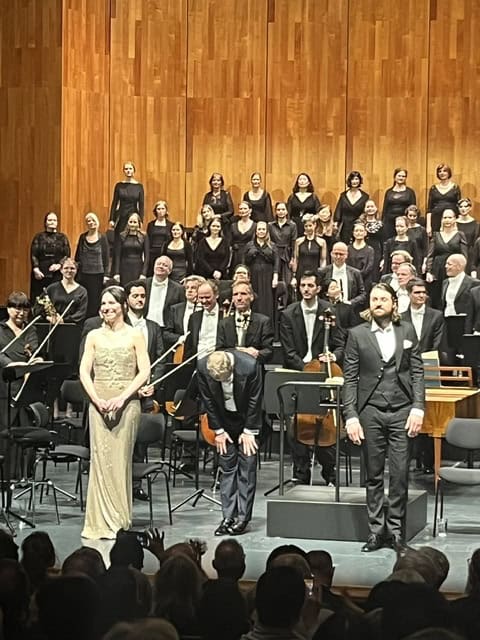 Corale Le Salon Musical in concerto Coro e orchestra Le Salon Musical durante un concerto sul palco in un teatro.