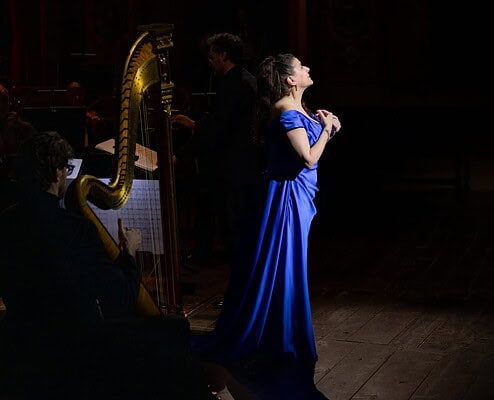 Cantante in abito blu durante esibizione di musica classica al Salone Musical.