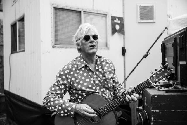 Robyn Hitchcock 1 Un musicista con chitarra in un ambiente di musica dal vivo, in bianco e nero.
