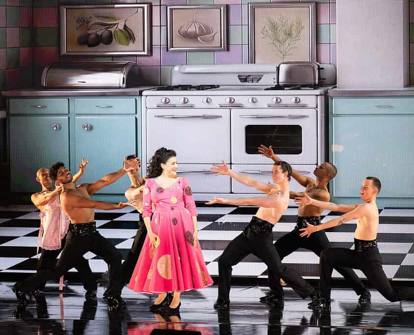 Il Salone Musical - Danza teatrale con attrice in cucina Attrice in costume rosa danza con ballerini in cucina, scena teatrale e coreografia artistica.