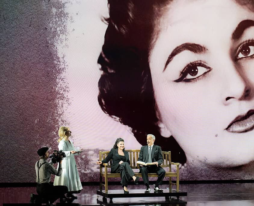 Eleganza e musica dal vivo Performers sul palco di Le Salon Musical con grande schermo di una donna iconica sullo sfondo.