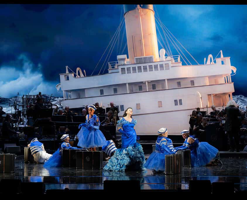 Il Salone Musical - Spettacolo teatrale con orchestra Spettacolo teatrale con nave e ballerini in costume blu sul palco.
