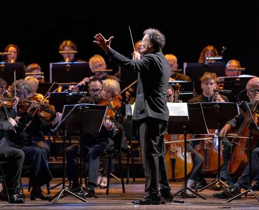 Un direttore d'orchestra guida un'orchestra sinfonica durante un'esibizione dal vivo.